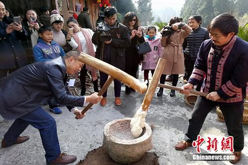 游客体验打糍粑。 卢文伟 摄