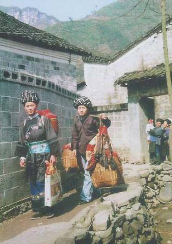 2 三朝回门：三朝已满客归还，夫妇回门去拜娘。女背篓来男扛筐，二人路上走忙忙。（砂刚摄影，向鹏程配诗）